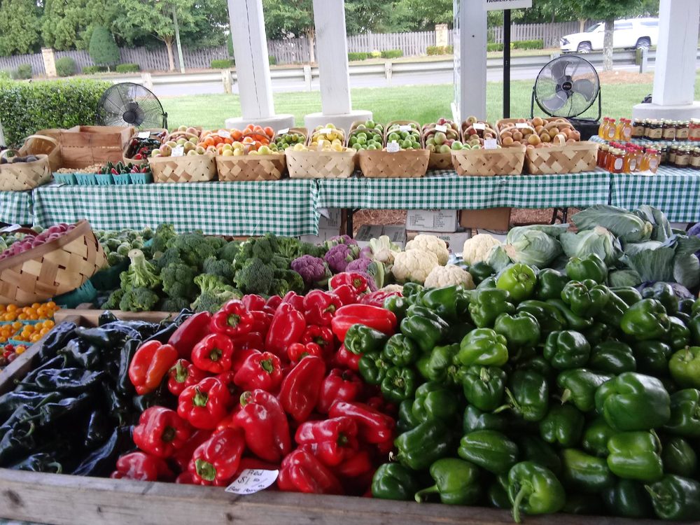 Baskets of fruit and jars of honey and preserves on the market table