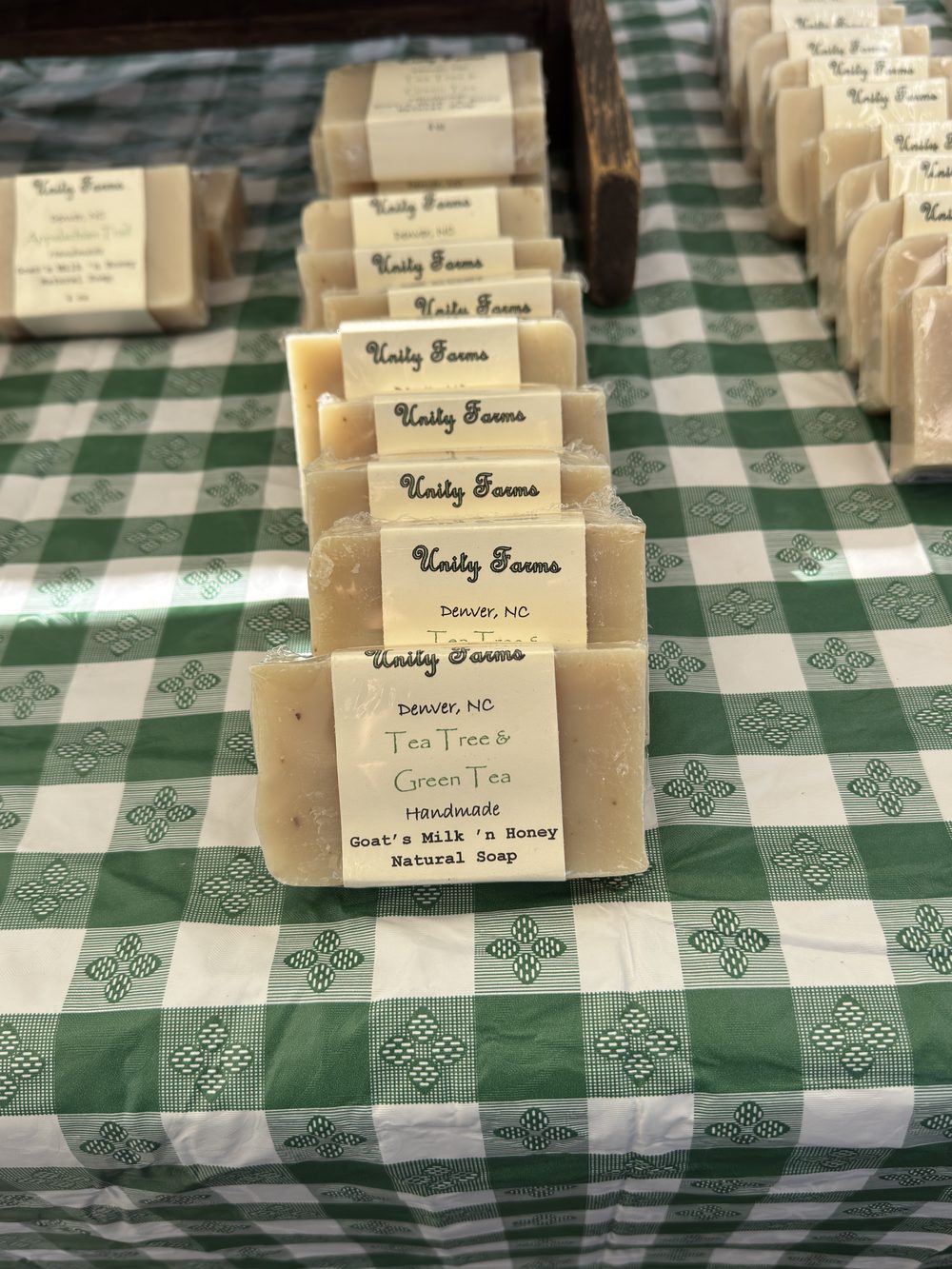 Handmade Unity Farms goats milk and honey soap bars lined up on the market table